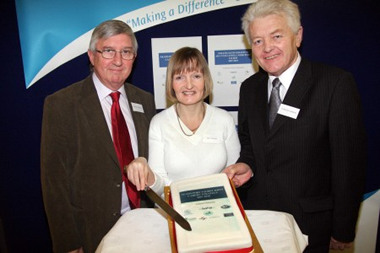 Photograph: pictured cutting the cake to celebrate the launch of the Neath Port Talbot Joint Carers Strategy (from left to right) are Dr Hywel Francis MP, carer Beverly Symonds and Cllr. Paul Thomas